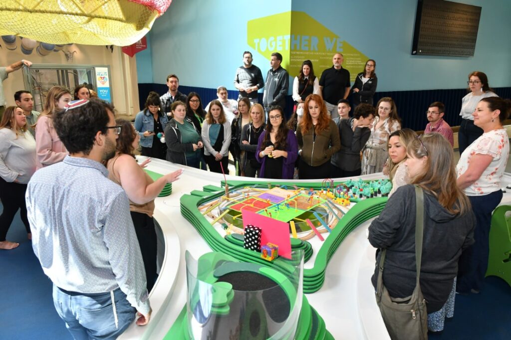 A group of people gathering by a prototype at the event