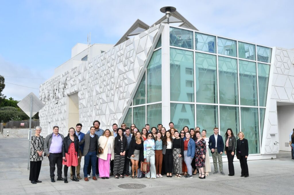 A photo of everyone at the immersive event in front of a white building